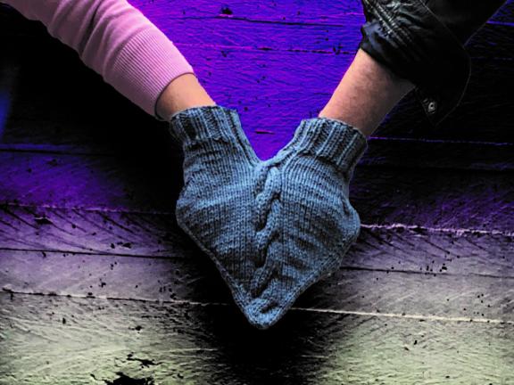 Zwei Hände halten sich und stecken in einem gemeinsamen Handschuh